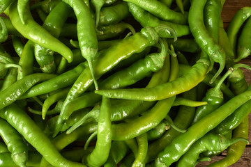 many green peppers on a kitchen bench.