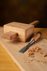 Woodworking tool. Mallet with chisel and savings on workbench.