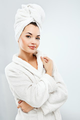 Attractive girl with dark hair wearing bath robe and towel
