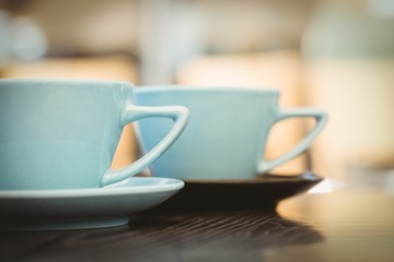 Cup of cappuccino with coffee art on wooden table