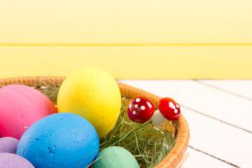 Colorful Easter eggs in basket on a wooden background. Eco-friendly material without violence against animals