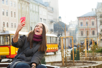 Young brunette woman laughing with smart phone