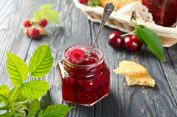 Cherry jam and raspberry on a rustic wooden table