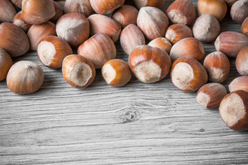Hazelnuts on gray wooden table.