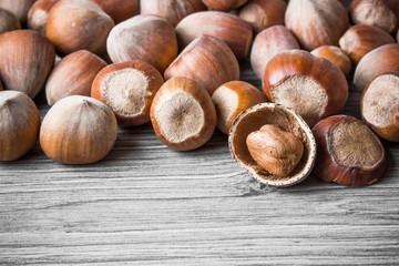 Hazelnuts on gray wooden table.