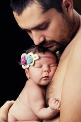 Young bearded father gently holds on his chest  newborn baby daughter © Yarkovoy