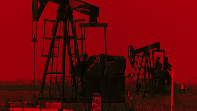 Oil reserves are near the end, flashing red light as a warning for the fuel reserve. Oil pump jack in a field.