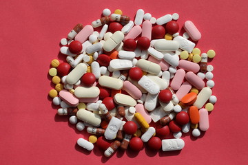 Medicine/Capsules and pills on red background.