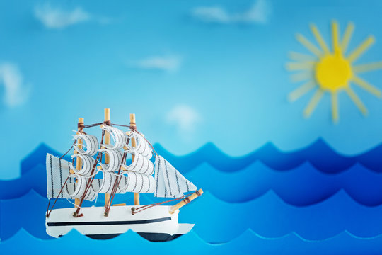 White Ship on blue wave with paper and sun. Travel and adventure concept