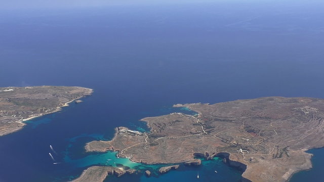 Aerial view of Malta Comino island with turquoise crystal clear water of Blue Lagoon between Comino and islet of Cominotto.Establishing shot, copyspace.
