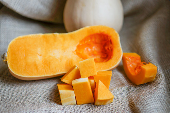 Uncooked sliced butternut squash on wooden background