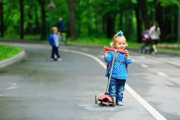 cute little girl with scooter in the park