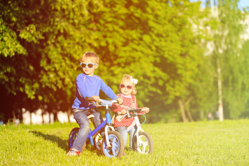 little boy and toddler girl on bikes in summer