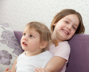 sisters sitting on   couch.