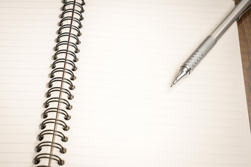 Note book with pencil on a wooden desk