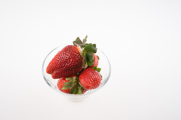 Fresh strawberries in a glass bowl isolated