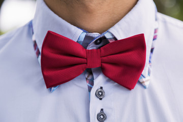 Man in a shirt and a red bow-tie.