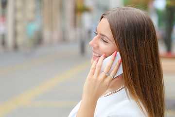 young business woman talking on phone on city walking street