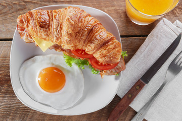 sandwich croissant with fried bacon cheese tomato breakfast and egg