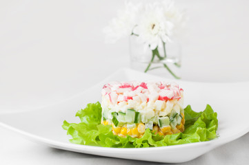 Layered crab sticks salad on lettuce leaves