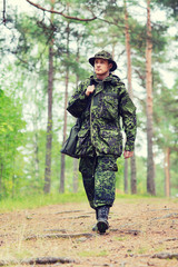 young soldier or hunter with gun in forest