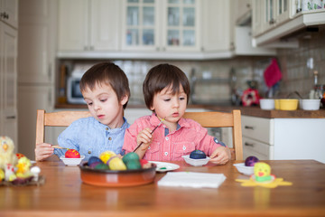 Fototapeta premium Two boys, coloring eggs for Easter