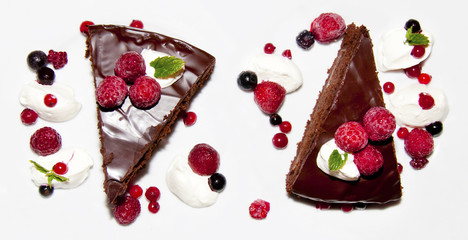 Two portions of chocolate dessert decorated with forest fruits and ice cream isolated on white background