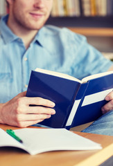 close up of student reading book at school