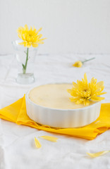 Obraz na płótnie Canvas Cheesecake in ceramic bowl with yellow flowers