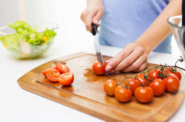 close up of woman chopping tomatoes with knife