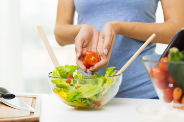 close up of woman cooking vegetable salad at home