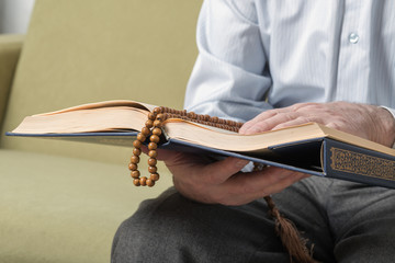 An old hands holding the Koran. Selective focus