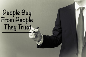 Business man writing - People Buy From People They Trust