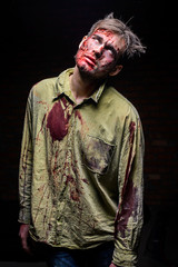 Scary looking demon man with bloodyface/Scary zombie in bloody clothes looks terrifying sight