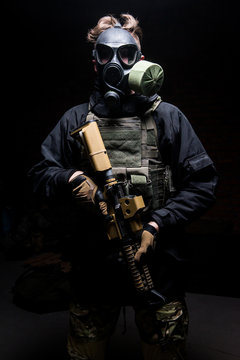 Soldier with rifle and gas respirator on his face/Man with rifle,gas respirator on his face  and body armor looking at camera