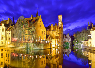Landmark architecture in Bruges town, reflected in water in evening lights