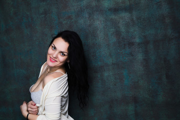 Studio portrait of a sexy brunette in grey lingerie and white cardigan