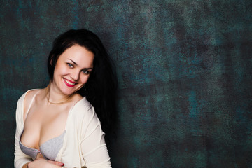 Studio portrait of a sexy brunette in grey lingerie and white cardigan