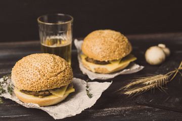 Burger on the black wooden background. Toned image.