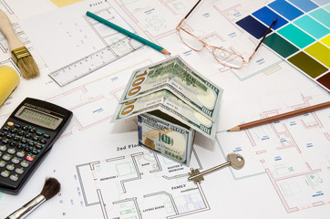 dollar banknotes as  model house on a construction plan for house building