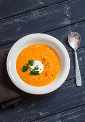 Healthy quinoa carrot soup on rustic light wooden board. Delicious vegetarian food