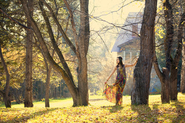 Girl in autumn park near the house