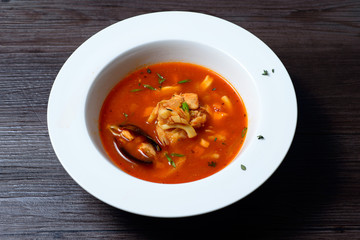 Delicious soup with mussels on black background