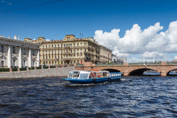 Fototapeta na wymiar Прогулочный катер на реке Фонтанка на фоне Аничкова моста, Санкт-Петербург, летний день