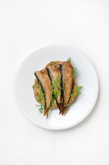 Sprats sandwiches on white plate
