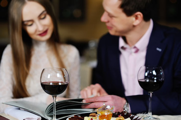 guy with a girl in a restaurant choose dishes from the menu