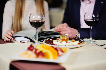 guy with a girl in a restaurant choose dishes from the menu