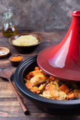 Tagine with cooked chicken and vegetables Wooden background Copy space