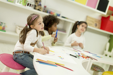 Multiracial children drawing in the playroom