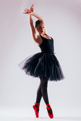 one caucasian young woman ballerina ballet dancer dancing with tutu in silhouette studio on grey background - obrazy, fototapety, plakaty